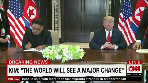 도널드 트럼프 미국 대통령과 김정은 북한 국무위원장이 6월 12일 싱가포르 카펠라 호텔에서 공동선언문에 서명하고 있다. 외신들은 이 회담을 ‘세계사적 사건’ ‘북미 관계의 해빙과 외교 프로세스의 시작’이라며 큰 의미를 부여했다. 미국 CNN 방송 화면.