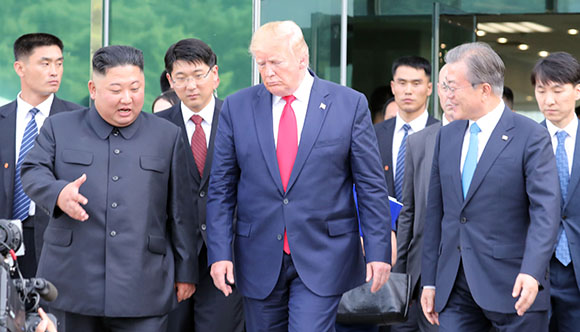 도널드 트럼프 미국 대통령, 김정은 북한 국무위원장이 30일 오후 판문점 남측 자유의 집에서 회동을 마친 뒤 문재인 대통령과 함께 군사분계선으로 이동하고 있다. 