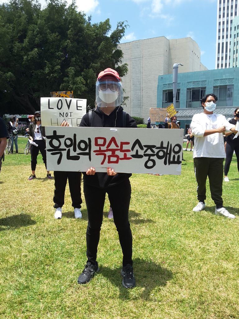 한글 메시지를 들고 서 있는 한국인 참가자