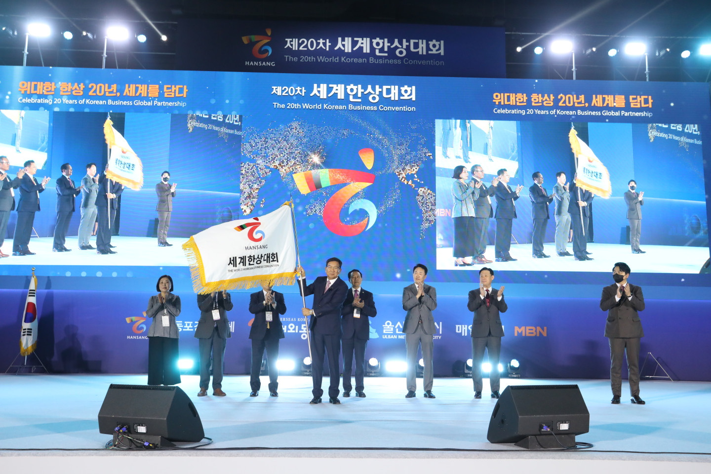 제20차 세계한상대회의 개막을 알리며 한상기를 흔드는 김점배 대회장