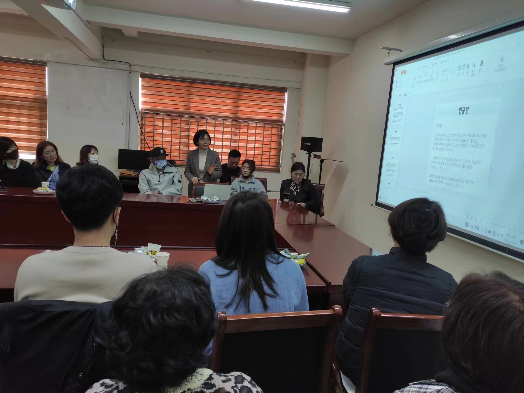 A representative explains class schedule during a parents' meeting of the Hangeul School in Qingdao