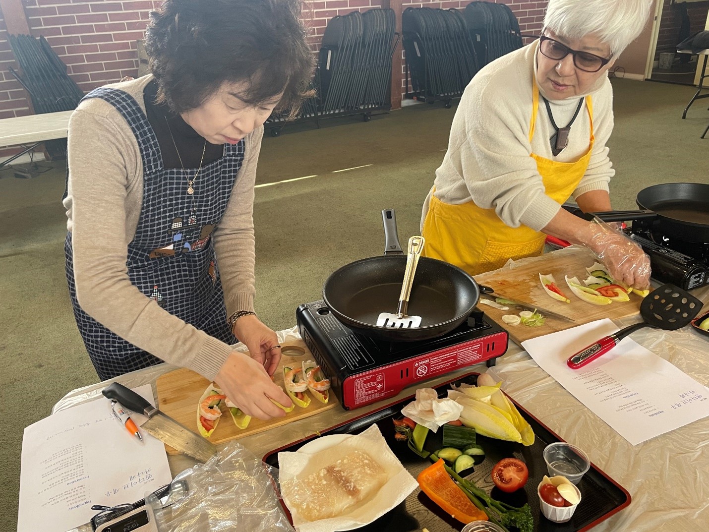 Members making shrimp canapes with endive