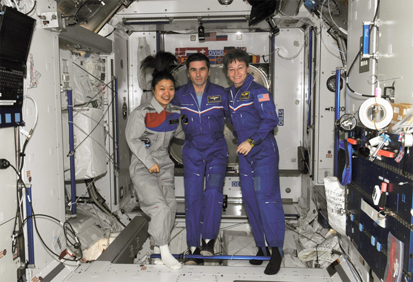 <한국의 우주인 이소연씨와 러시아의 우주인 유리 말렌첸코(Yuri Malenchenko – 가운데), 그리고 나사(NASA)의 우주인 페기 윈스턴(오른쪽)이 인터내셔널 우주선에 동승하는 동료 우주인들을 위해 김치 요리를 준비한 후 포즈를 취했다. = 사진 출처: NASA>